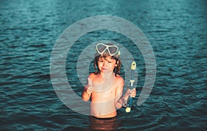 Boy kid swim on the beach on summer holidays. Child in nature with beautiful sea. Happy kids swimming in the water.