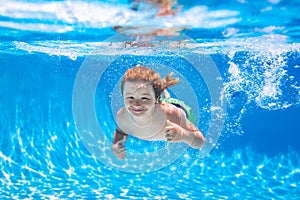 Boy kid swim and dive underwater. Under water portrait in swim pool. Child boy diving into a swimming pool.