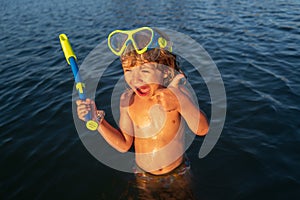Boy kid swimming on the beach on summer vacation. Child in sea. Happy children swimming and snorkeling in tropical ocean