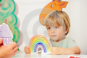Boy in kindergarten class hold the cart with rainbow card