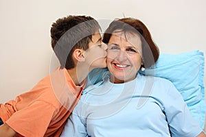 A boy kissing her grandmother