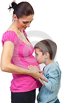 Boy kissing his mother pregnant tummy