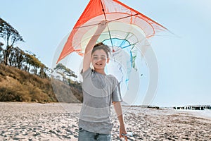 Boy with kite on the beach. Family summer beach vacation by the sea. Freedom and an active lifestyle. Happy childhood