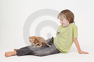 Boy with kitten sitting over white background