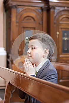 Boy kneeling and praying in the church.