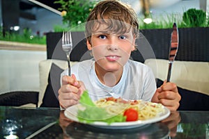 boy with a knife and fork in front of a plate of photo