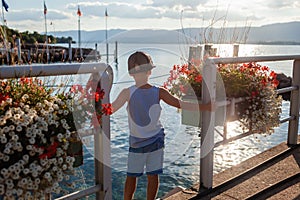 Boy on Lake Leman pier at sunset.