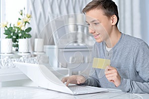 Boy with laptop and credit card