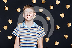 Boy laughing on golden hearts background
