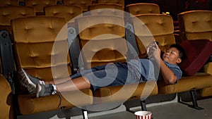 A boy laying down and playing mobile phone