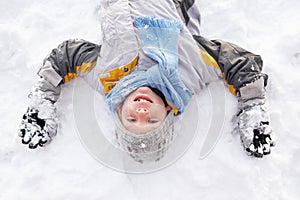 Boy Laying On Ground Making Snow Angel