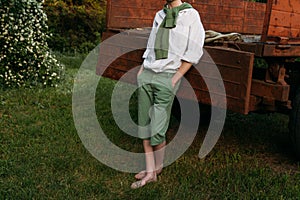 The boy is leaning on the old truck cousin, barefoot on the grass in the summer. hands in pockets