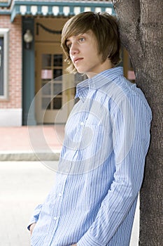 Boy leaning on tree