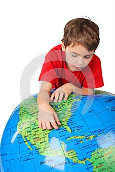 Boy leans on inflatable globe isolated on white