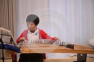 boy learn to play guzheng music photo