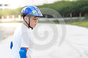 Boy learning skating outdoor, sweats on his face..