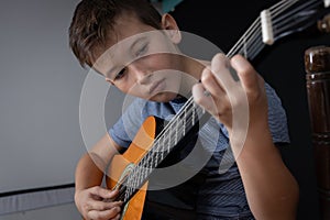Boy learning to play acoustic guitar. Boy is practicing acoustic guita