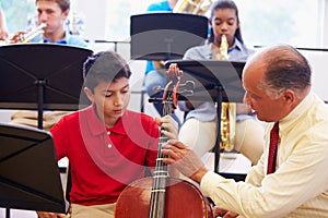 Boy Learning To Play Cello In High School Orchestra