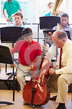 Boy Learning To Play Cello In High School Orchestra