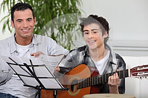 Boy learning to play the guitar