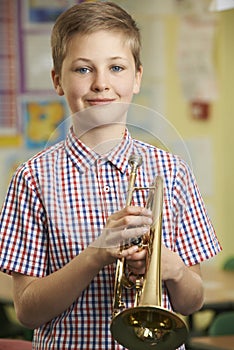 Boy Learning To Play Trumpet In School Music Lesson