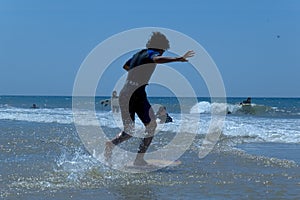 Boy learning to surf on beach