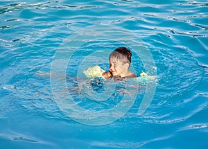 Boy learning to swim in the pool