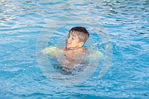 Boy learning to swim in the pool