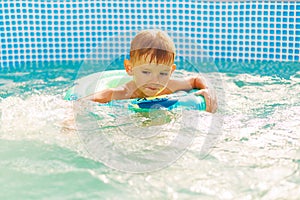 Boy Learning to Swim in Pool with Float Ring