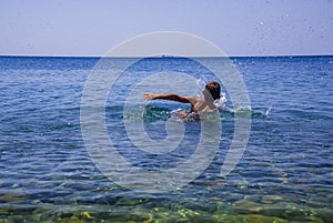 Boy learning to swim in the sea