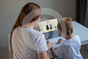 A boy learns the alphabet with a laptop teacher. Distance learning by video conference. Remote preschool education.