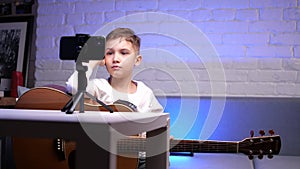 a boy learns to play the guitar using a mobile application