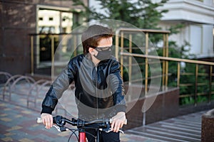 Boy in a leather jacket wearing a black hygyenic medical mask