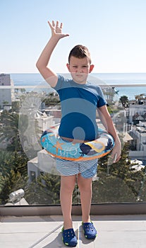 Boy with a life buoy is waiting for  trip to the sea