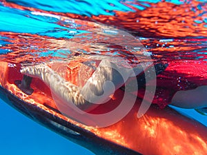 A boy in a life jacket swims with underwater scooter seabob. Close-up.