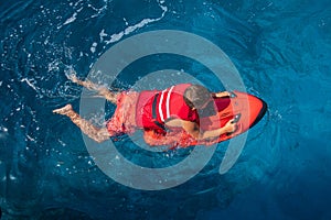 A boy in a life jacket swims with underwater scooter seabob off the coast of the ANTIPAXOS island, Greece in summer.