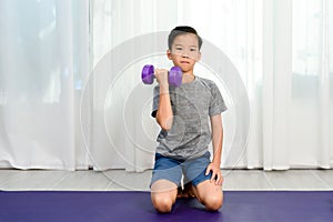 Boy lift dumbell by his strong arm