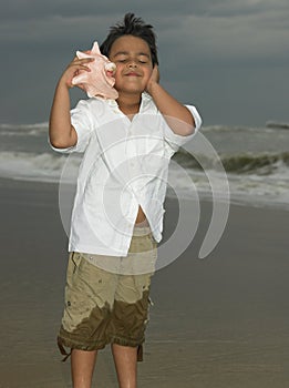 Boy listening to a conch