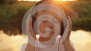 Boy listening to music in headphones on a nature, summer, sunset