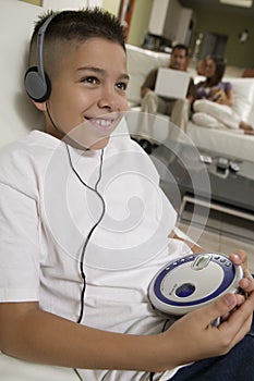 Boy Listening to Music on Portable CD Player in living room