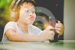 The boy listening to music from smartphone