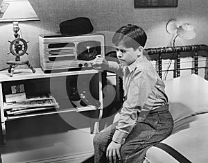 Boy listening to radio in bedroom photo