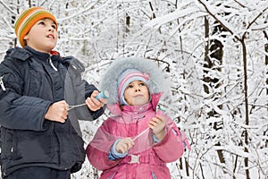 Boy and little girl with petard in hands in winter