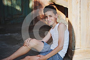 Boy with little yellow duckling in summer village