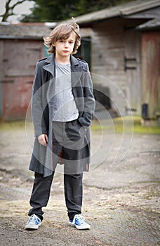 Boy in Long Coat Standing in a Farm Yard