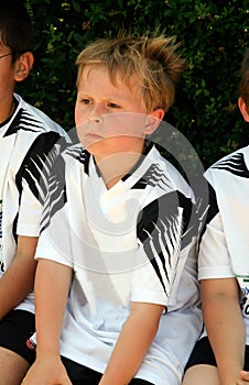 Boy is looking angry and sad from soccer playing because they ar