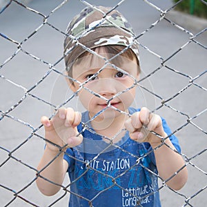 Boy looking through the bars