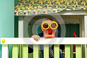 Boy looking through binoculars in the children`s room