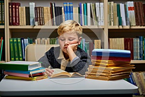 boy looking bored while studying at the library