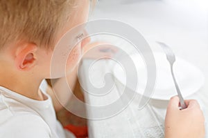 Boy is looking at an empty plate